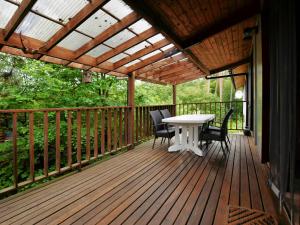 una terraza de madera con mesa y sillas. en Cosy chalet in Barvaux with fenced garden en Barvaux