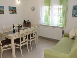 uma sala de estar com uma mesa e cadeiras e um sofá em Charming Apartment in Greba tica with Terrace em Grebaštica
