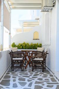 a patio with a wooden table and chairs on a balcony at Filoxenia Apartments in Adamas