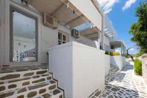 a white building with a white wall and a black and white tile floor at Filoxenia Apartments in Adamantas