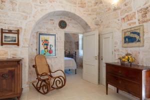 einen Stuhl in einem Zimmer mit einer Steinmauer in der Unterkunft Stile e relax nei trulli by Wonderful Italy in Martina Franca