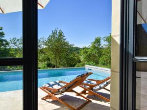 ein Paar Liegestühle auf einer Terrasse neben einem Pool in der Unterkunft Holiday home near Thizay with private pool in Thizay