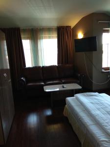 a hotel room with a couch and a bed at Roots Hotel Old Town in Plovdiv