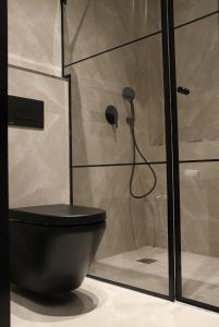a bathroom with a black toilet and a shower at Jaffo Tel-Aviv King Gallery Boutique Hotel in Tel Aviv