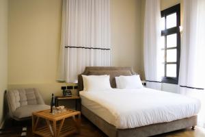 a bedroom with a bed and a chair and a window at Jaffo Tel-Aviv King Gallery Boutique Hotel in Tel Aviv +45 photos