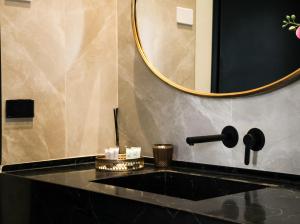a bathroom with a black counter and a mirror at Jaffo Tel-Aviv King Gallery Boutique Hotel in Tel Aviv