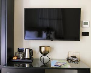 a flat screen tv hanging on a wall above a counter at Jaffo Tel-Aviv King Gallery Boutique Hotel in Tel Aviv