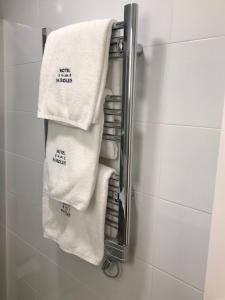 a towel rack in a bathroom with white towels at San Pablo Rooms in Córdoba