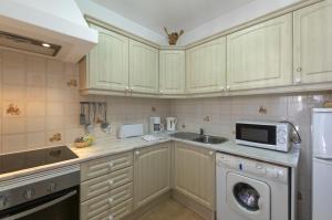 a kitchen with a microwave oven and a sink at Rocha Brava Village Resort in Carvoeiro
