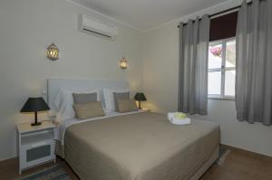 a bedroom with a large bed and a window at Rocha Brava Village Resort in Carvoeiro