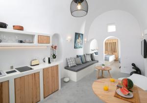 a kitchen and a living room with a table at Demeter Cave House - Luxury Adults Only Cave House in Pyrgos