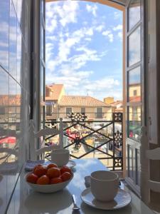 a table with a bowl of tomatoes and a view of a balcony at La Casa de Mansilla in Mansilla de las Mulas