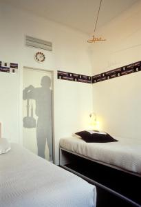 ein Schlafzimmer mit 2 Betten und eine Person, die ein Foto macht in der Unterkunft Le Windsor, Jungle Art Hotel in Nizza