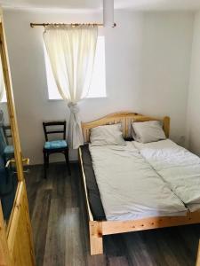 a bed in a room with a window at Little Greece in Balatonfüred