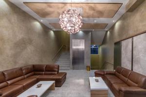 a lobby with brown leather couches and a chandelier at HOTEL FRANCA ULCINJ in Ulcinj
