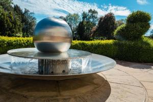 a water fountain with a ball in the middle at Thornton Hall Hotel & Spa in Heswall
