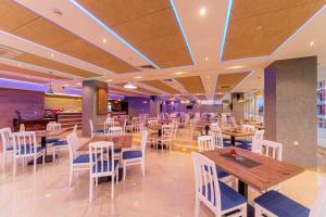 a restaurant with wooden tables and white chairs at HOTEL FRANCA ULCINJ in Ulcinj +23 photos