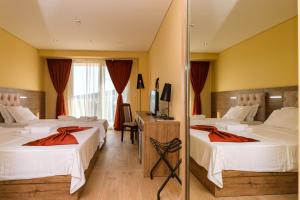 a hotel room with two beds and a mirror at HOTEL FRANCA ULCINJ in Ulcinj