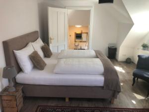 a bedroom with a large bed with white sheets and pillows at Fenix Hall Boutique Hotel Hallstatt in Hallstatt