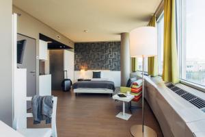a hotel room with a bed and a living room at harry's home hotel & apartments in Vienna