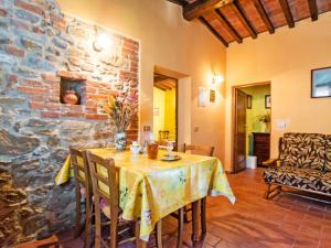 Un comedor con una mesa y una pared de piedra. en Apartment Il Mirto by Interhome, en La Collina