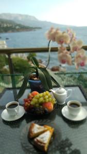 a table topped with plates of food and cups of coffee at Health complex Beliy Parus in Foros