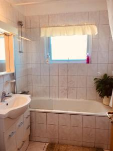 La salle de bains est pourvue d'une baignoire, d'un lavabo et d'une fenêtre. dans l'établissement Guesthouse Árný, à Îles Vestmann