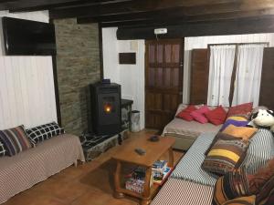 ein Wohnzimmer mit 2 Sofas und einem Holzofen in der Unterkunft La Terraza de Onís in Bobia de Arriba