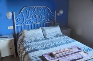 a bedroom with a bed with a blue wall at La Terraza de Onís in Bobia de Arriba