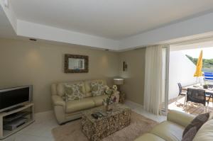 a living room with a couch and a television at Rocha Brava Village Resort in Carvoeiro