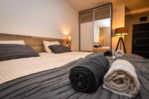 1 dormitorio con 2 camas y toallas negras. en Miido Apartments en Kladovo