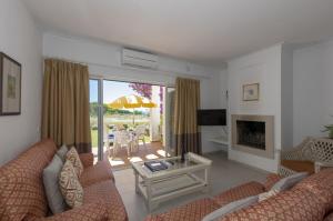 a living room with a couch and a table at Rocha Brava Village Resort in Carvoeiro