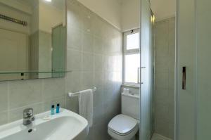 a bathroom with a sink and a toilet and a mirror at Rocha Brava Village Resort in Carvoeiro