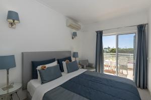 a bedroom with a large bed and a balcony at Rocha Brava Village Resort in Carvoeiro