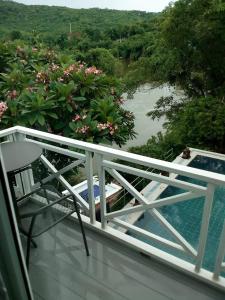 a balcony with a view of a river and trees at Jung Ja Hut in Sai Yok