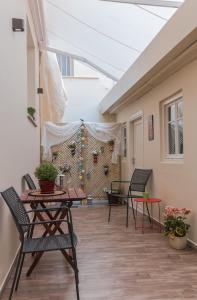 a patio with chairs and tables and a wall with plants at Saint George unique studio in Nafplio