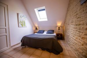 Un dormitorio con una cama con almohadas azules. en La Ferme de L'Oudon & SPA, en Berville