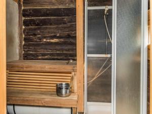 a shower stall with a bucket on a wooden shelf at Holiday Home Tievatupa 1- isompi by Interhome in Ylläsjärvi