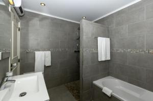 a bathroom with a sink and a bath tub at Rocha Brava Village Resort in Carvoeiro