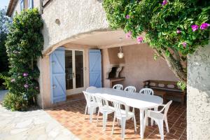 a patio with a white table and white chairs at Villa provençale avec piscine-56 in La Garonnette-Plage