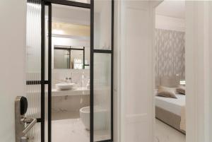 ローマにあるBea Suites Luxury Roomsのバスルーム(ベッド1台、シンク、鏡付)
