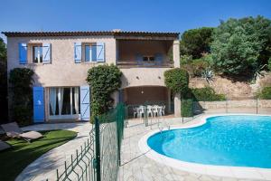 a villa with a swimming pool in front of a house at Villa provençale avec piscine-56 in La Garonnette-Plage