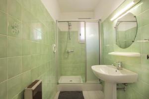 a green tiled bathroom with a sink and a shower at Villa provençale avec piscine-56 in La Garonnette-Plage +13 photos