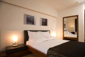 a bedroom with a bed with two lamps and a mirror at Surmeli Istanbul Hotel in Istanbul