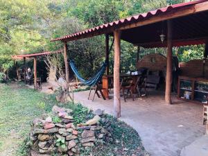 a patio with a hammock and a table and chairs at Quinta Conciencia in Samaipata