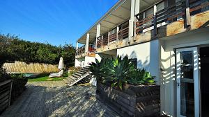 a house with a patio and a porch with a plant at Dassen Island 61 in Plettenberg Bay