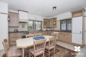 a kitchen with wooden cabinets and a table and chairs at Villa Joselina in Vilamoura