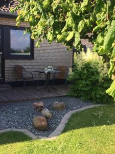 a patio with a table and chairs in a yard at Nordseeperle Husum in Husum