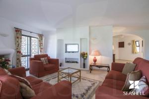 維拉摩拉的住宿－Villa Joselina，客厅配有两张红色的沙发和一张桌子