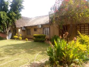 a house with a garden in front of it at Ntshe River Lodge in Francistown +9 photos